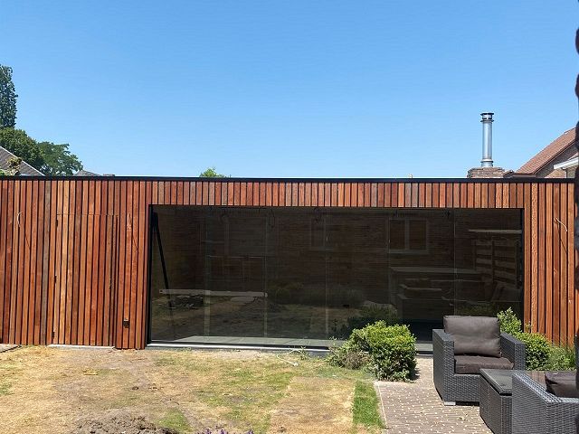 Bijgebouw met glazen schuiframen te Ravels