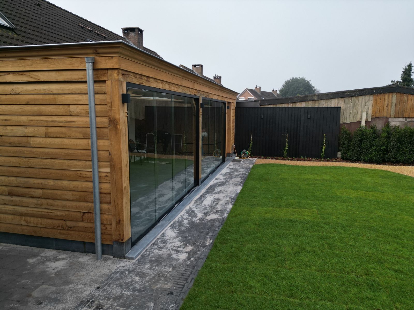 Tuinaanleg met overkapping en tuinberging te Weelde