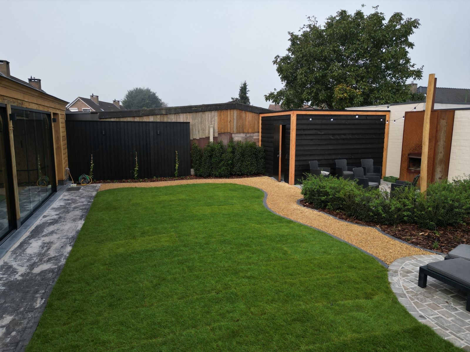Tuinaanleg met overkapping en tuinberging te Weelde